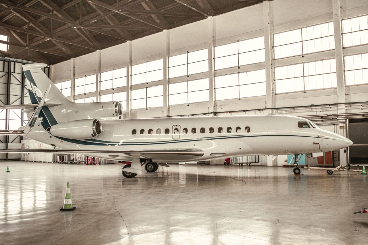 Luxurious private jet parked inside a well-lit hangar in Paris, France.