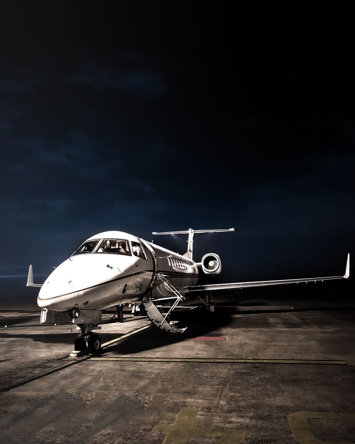 A sleek private jet illuminated on a tarmac at night in Jakarta, Indonesia, exuding elegance and luxury.